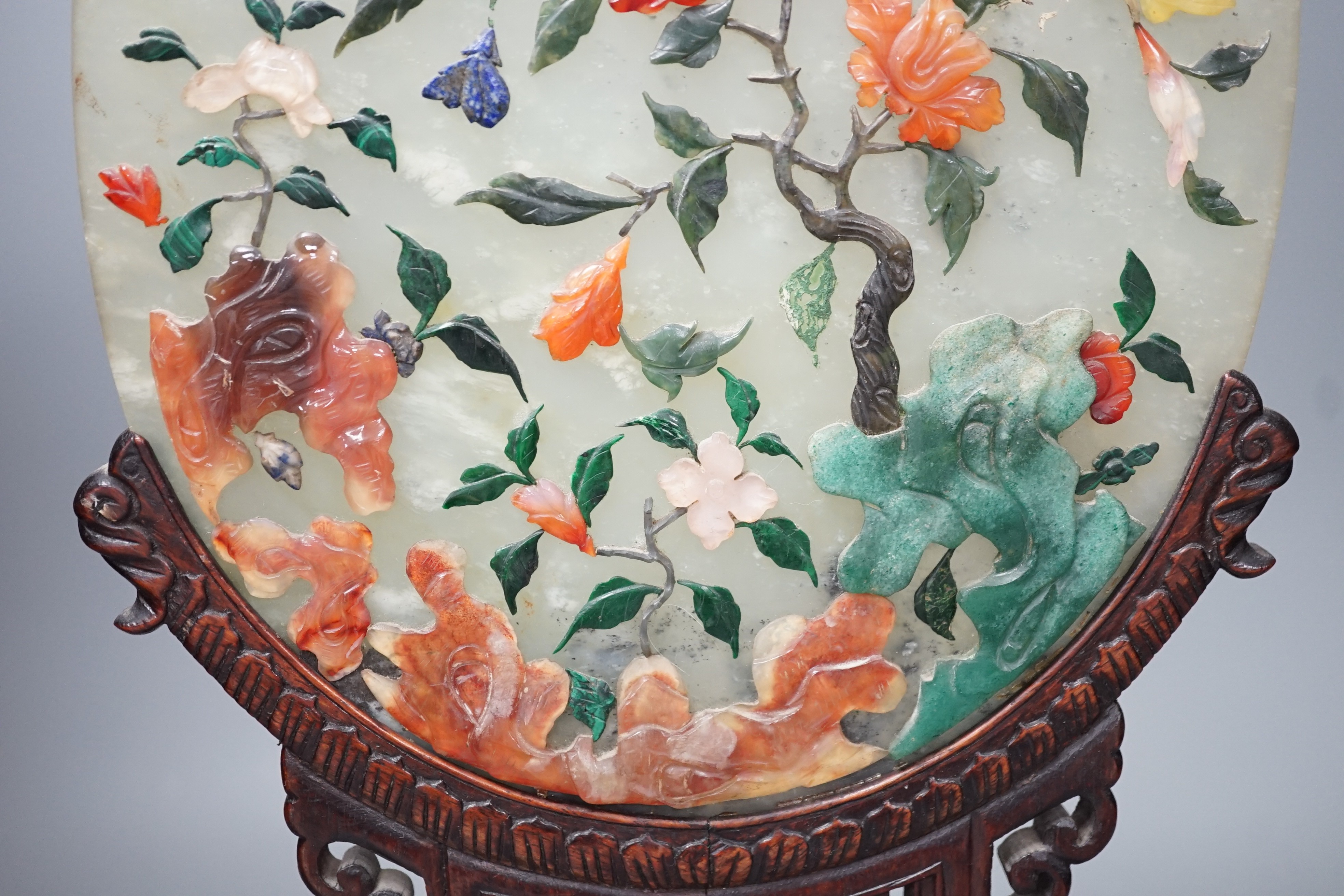 An early 20th century Chinese carved hardstone table screen with pierced hardwood stand Height 44cm Width 21cm